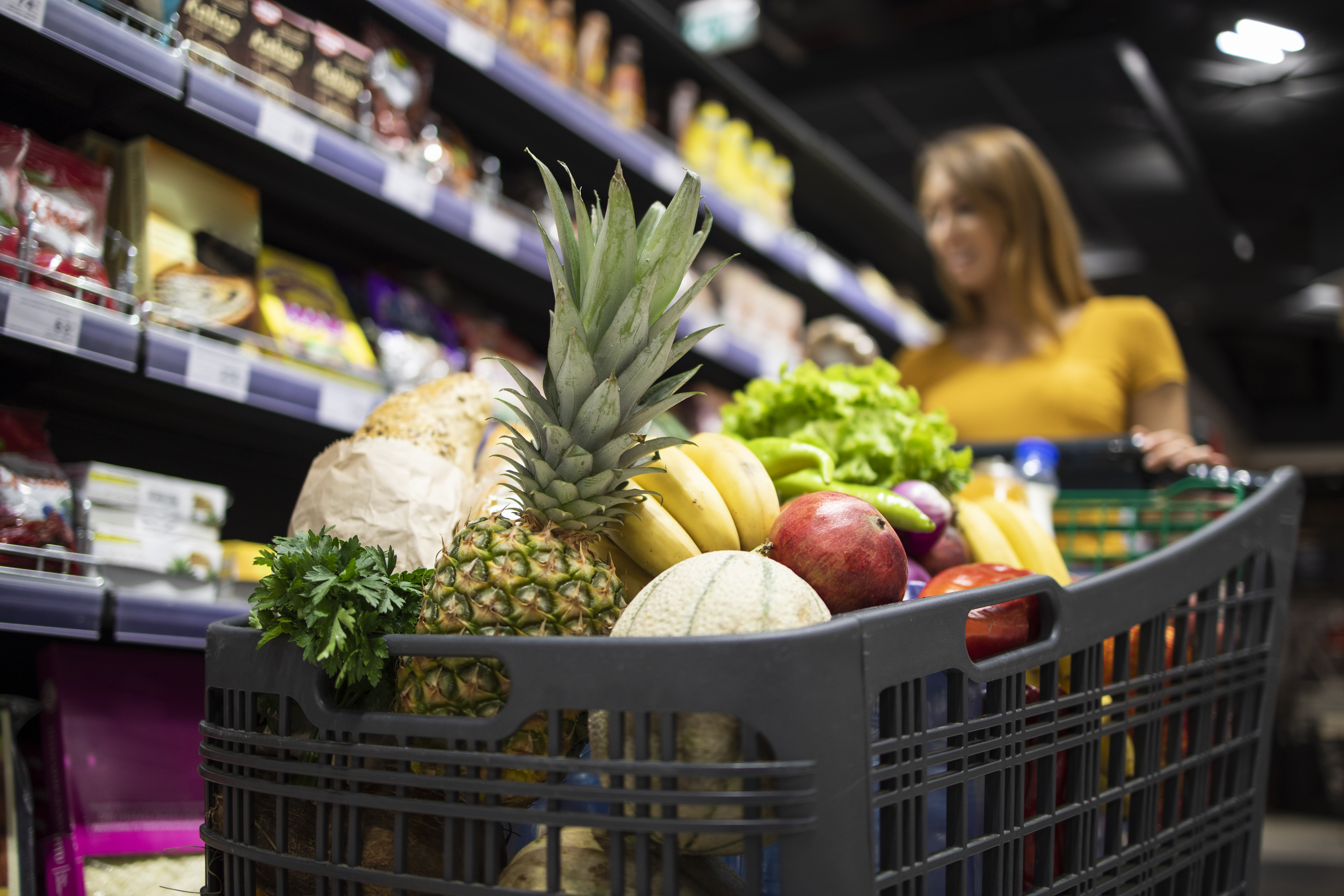 Carrinho de compras de supermercado repleto de frutas e legumes